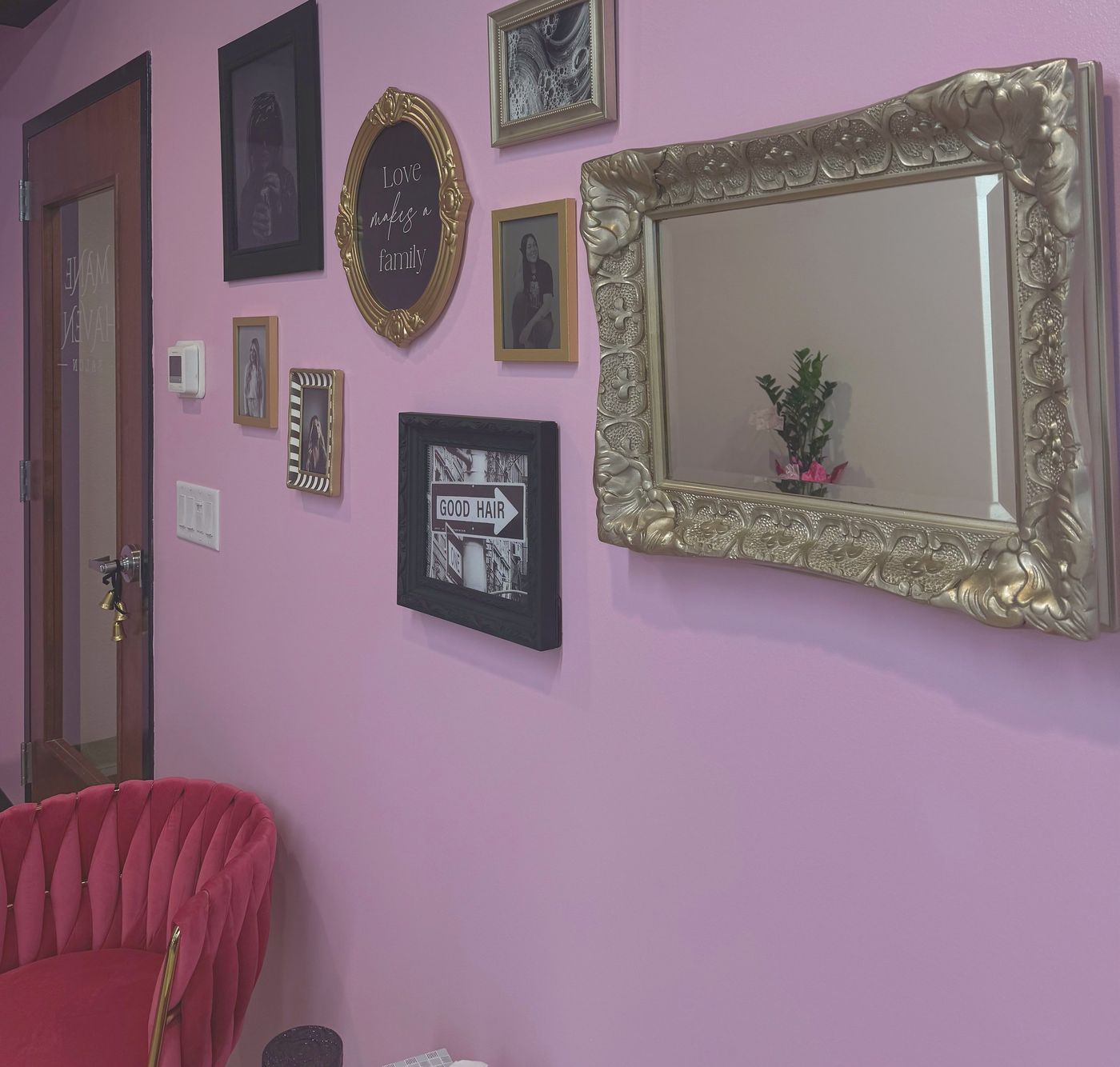 Pink waiting lounge with gold mirror at Mane Haven Salon in Bismarck
